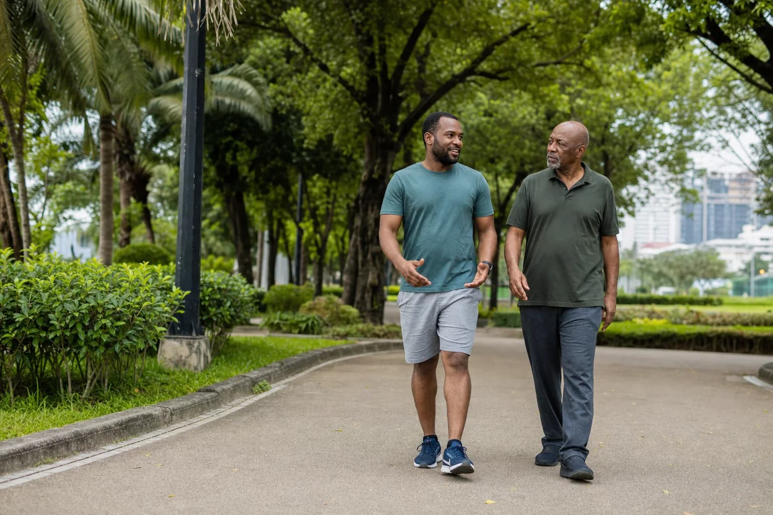 Adult son and older father walking together outdoors